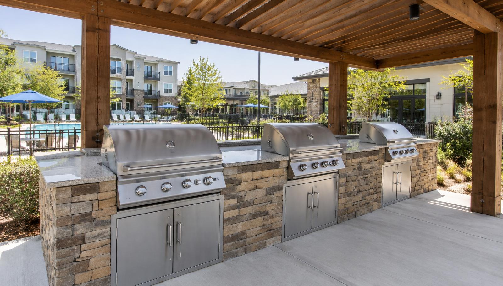 Community outdoor kitchen and shared grill station with multiple built-in grills